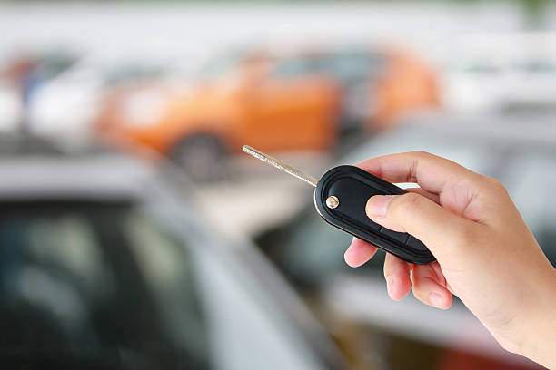 istock Hand hold car key remote on blur car parking 589122110