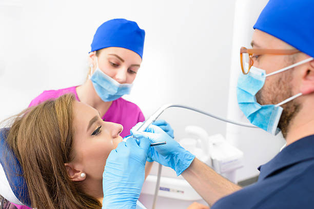 femme recevant un traitement dentaire - dental assistent photos et images de collection
