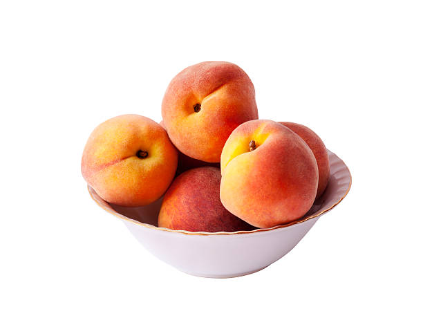 istock Ripe peach fruit in bowl, isolated on white background 589124286