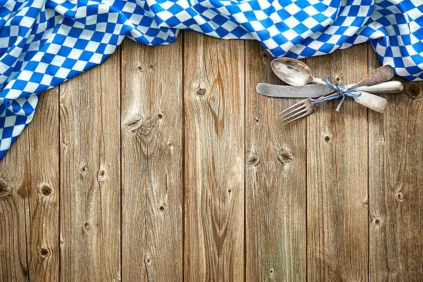 Rustic background for Beer Fest with Bavarian white and blue fabric and silverware