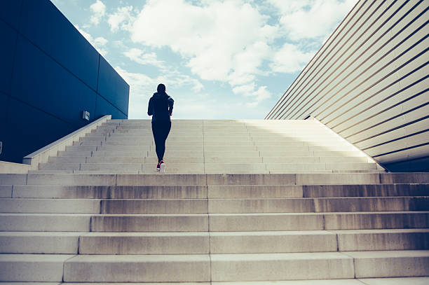 Climbing Up The Stairs Woman exercising on a staircase outside in the city. outdoor staircase stock pictures, royalty-free photos & images