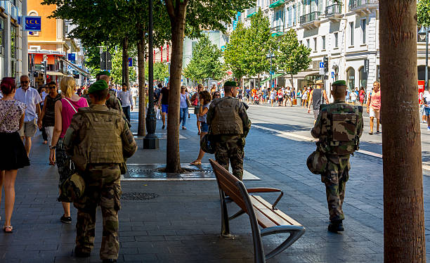 Army on the streets of Nice, France after Terrorist Attack Nice, France - August 12, 2016: Four male army soliders or armed services on the streets of Nice in France. This is due to the Nice terrorist attack on 14 July 2016. A truck was deliberately driven into crowds on the Promenade des Anglais resulting in the death of 85 people and injuring 307. Shoppers and tourists walk the main high street in the town centre. islamic state stock pictures, royalty-free photos & images