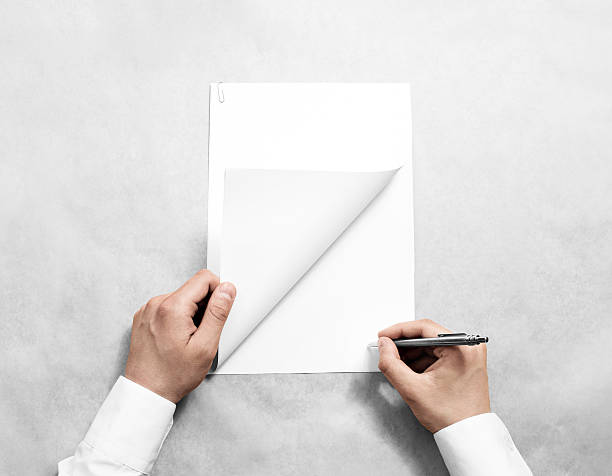 istock Hand holding blank agreement mockup and signing it. 589127962