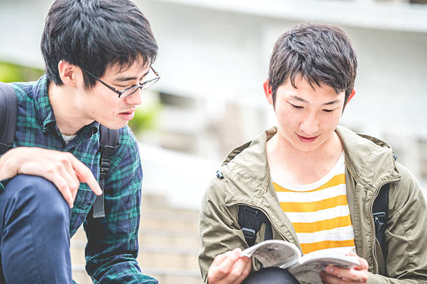 istock Two Japanese Students Reading on Staircase, Campus, Kyoto, Japan 589128140