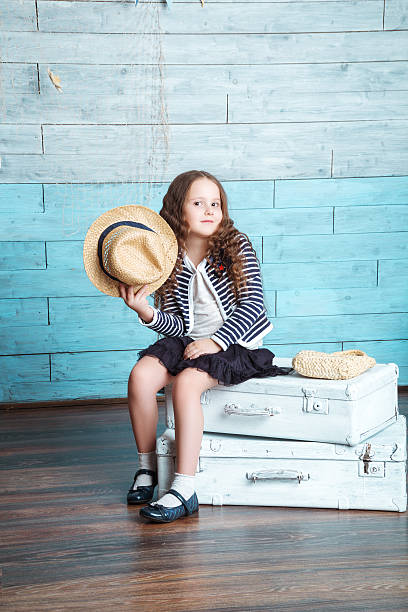 istock little girl sitting on suitcases 589128706