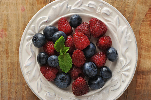 istock blueberries and raspberries with mint in bowl 589129274