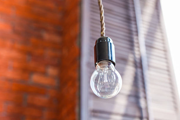 istock Incandescent lamp on a brick wall background 589130864