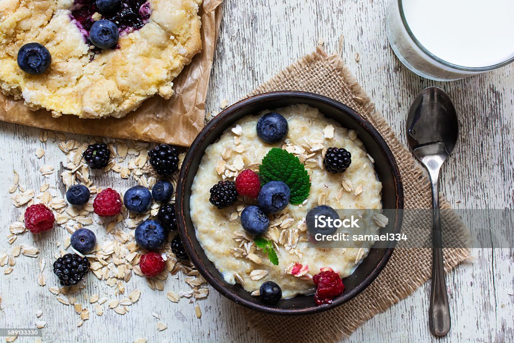 healthy breakfast. oatmeal, homemade blueberry cake and milk healthy breakfast with bowl of berry oatmeal, homemade blueberry cake and glass of milk with a spoon.top view Bakery Stock Photo