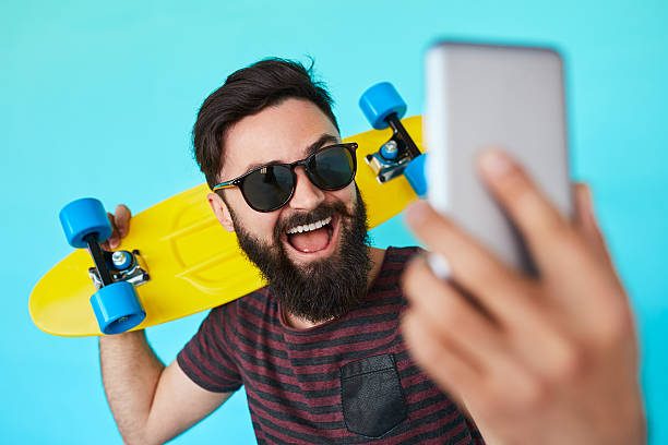 istock young handsome bearded hipster man makes selfie 589133950