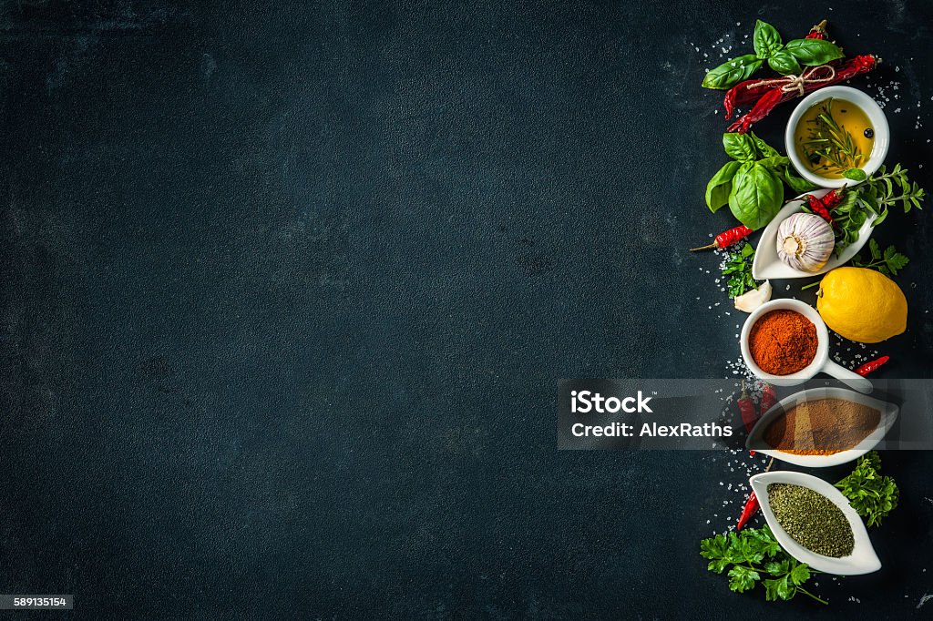 Herbs and spices over black stone background Herbs and spices over black stone background. Top view with copy space Backgrounds Stock Photo