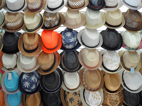 Display of lots of different style straw hats at an open-air market in northern Majorca, Spain.
