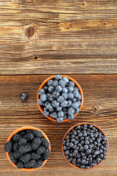 istock Fresh blueberries and blackberries on old wooden background 589415262