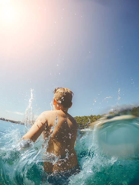 istock Boy jumps to the sea 589415786