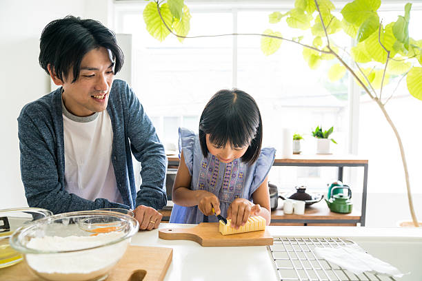 istock Young daughter looking happy while baking and bonding with father 589416160
