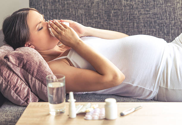 Pregnant woman having cold stock photo