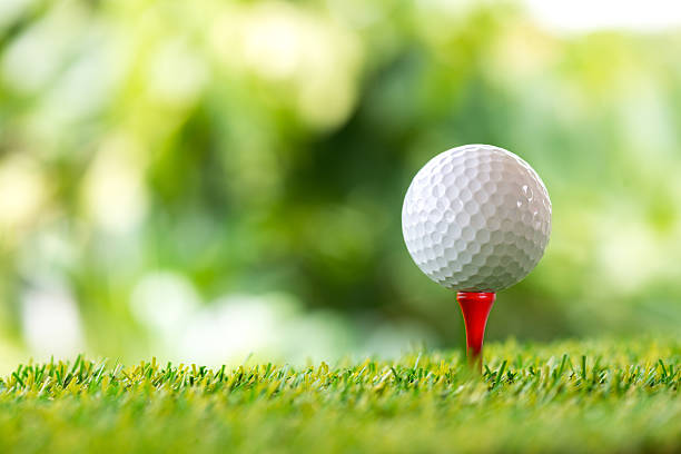 golfball auf tee  - golf golf ball tee green stock-fotos und bilder