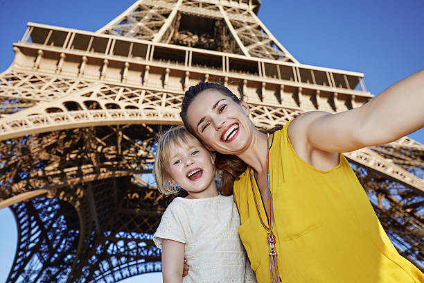 istock mother and child taking selfie in front of Eiffel tower 589418926