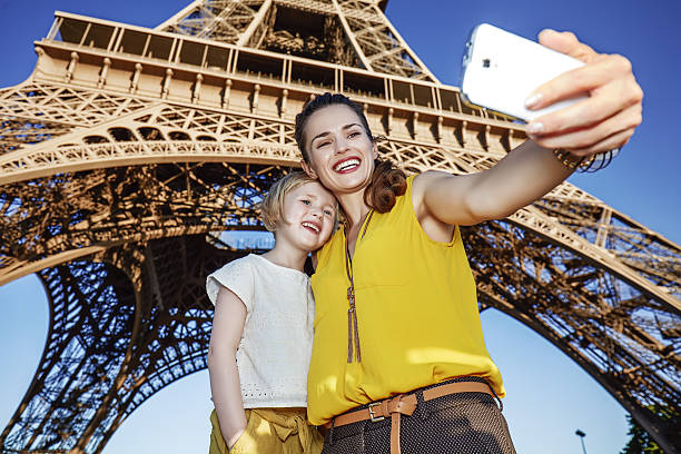 istock mother and child tourists taking selfie against Eiffel tower 589419220