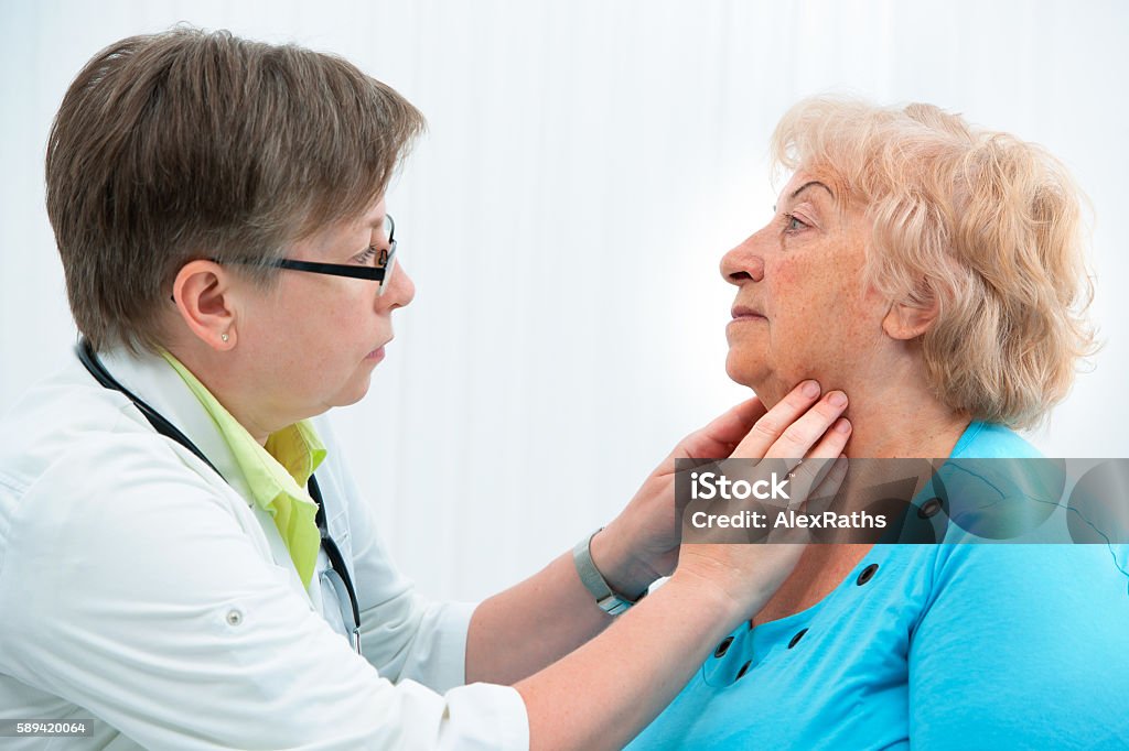 Thyroid function examination Thyroid function examination. Doctor touching the throat of a patient in the office Thyroid Gland Stock Photo
