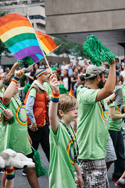 Young boy during the gay parade Montreal 2016 Montreal, Canada - August 14, 2016: A young boy is waving his gay flag during the gay parade Montreal, Canada, Montreal, Quebec. trans boy stock pictures, royalty-free photos & images