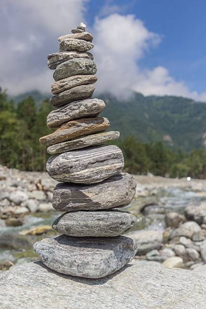 istock Pyramid from stones on river bank against a mountain landscape. 589421896