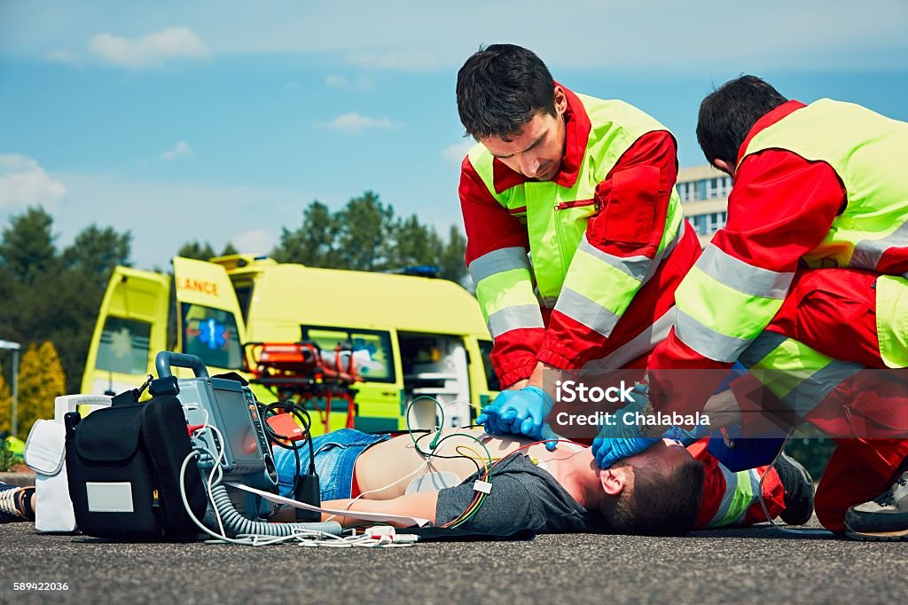 Emergency medical service Cardiopulmonary resuscitation. Rescue team (doctor and a paramedic) resuscitating the man on the street. Paramedic Stock Photo