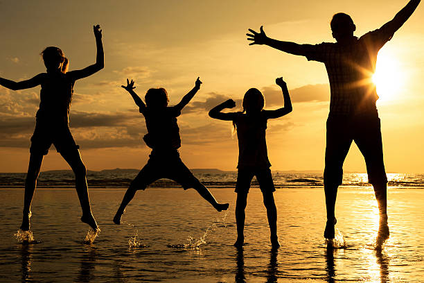 istock Father and children playing on the beach at the sunset 589425844