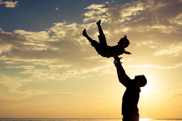 istock Father and son playing on the beach at the sunset 589426824