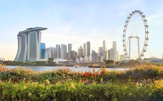 Singapore City, Singapore - December 29th, 2023: Singapore Urban Skyline and Cityscape - Skyline at Marina Bay in colorful twilight after sunset. Drone Point of view panorama. Green illuminated Towers. View over the glowing Singapore Waterfront Highway and City Road and Bridges towards Modern Skyscrapers under moody twilight skyscape. Singapore, Southeast Asia, Asia