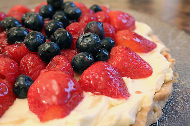 istock Glazed blueberry raspberry and strawberry tart pudding with cream base 589434178