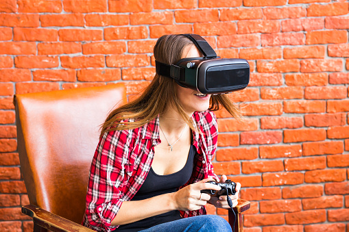 3d technology, virtual reality, entertainment and people concept - happy young woman with virtual reality headset or 3d glasses playing game and fighting