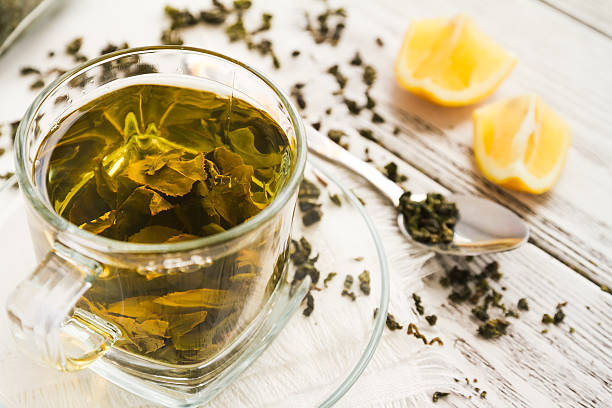 istock Cup of dreen tea with lemon on a table 589434930