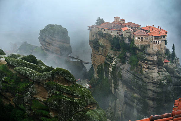 Monastery on top of a rock at Meteora Greek monastery on top of a rock, at Meteora, a village located at Kalampaka, Greece. The phoro is taken in a foggy weather. monk religious occupation photos stock pictures, royalty-free photos & images