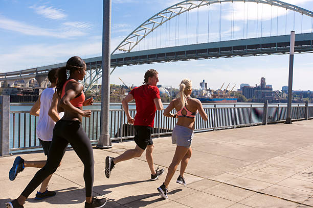 istock Young ethnic athletic group joggin along a pier 589435928