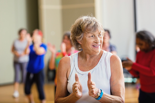 Mujer mayor aprendiendo movimiento de baile en el centro de mayores photo