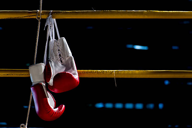 guantes de boxeo cuelga del ring de boxeo - guante deportivo fotografías e imágenes de stock