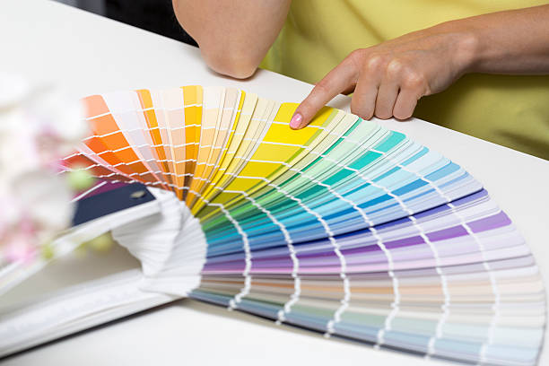 istock woman choosing paint color from tone samples 589438970