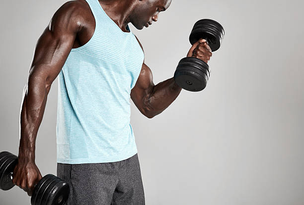 jeune homme faisant de l’exercice avec des poids de la main - men weight training african descent male photos et images de collection