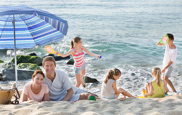 parents and playing children on beach - family large american culture fun imagens e fotografias de stock