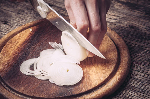 istock Cutting and chopping onion on wooden board with knife 589440820