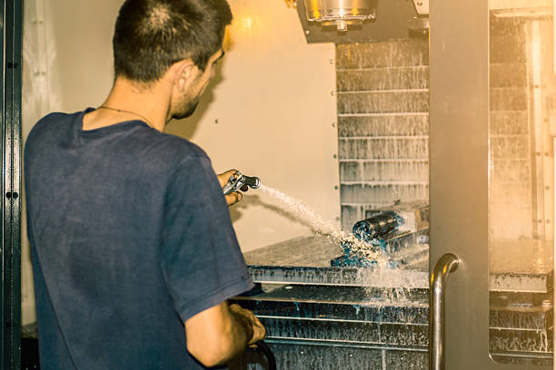 istock Worker washing CNC machine after finished job. 589441506