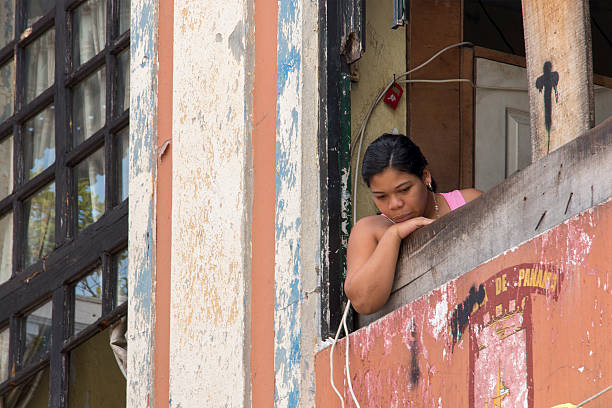Young Panamanian woman looking out of her window Panama City, Panama - August 12, 2016: Young Panamanian woman looking out of her window in the Casco Viejo or old town of Panama City. casco viejo photos stock pictures, royalty-free photos & images