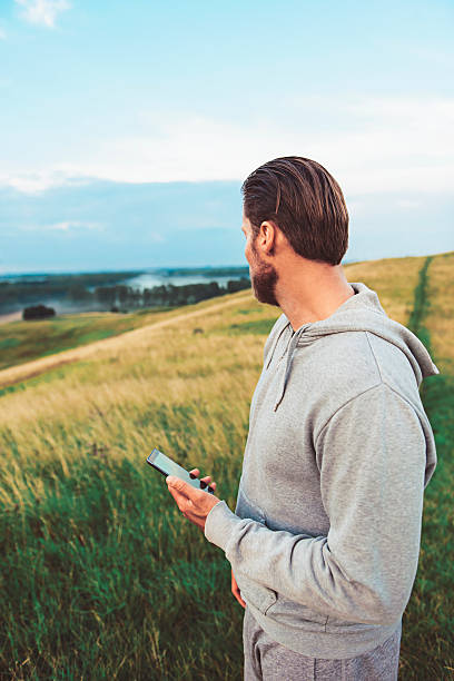 istock Runner looks at scenic view while holding smart phone 589446724