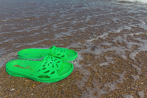 istock Green slippers lie on the seashore. Recreation 589447640