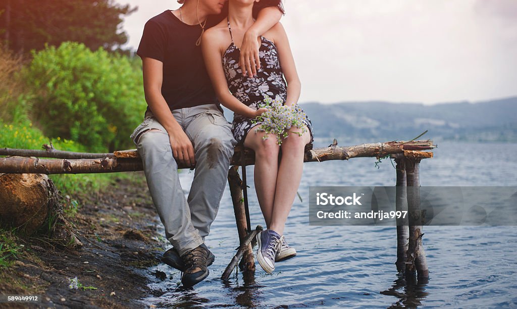 Romance by the lake A couple enyoing and relaxing by the lake. Teenage Couple Stock Photo