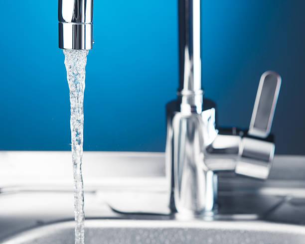 istock mixer tap with flowing water 589450062