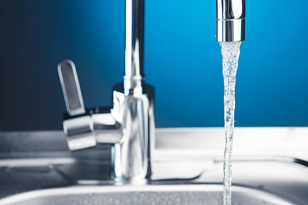 istock mixer tap with flowing water, closeup view 589450080