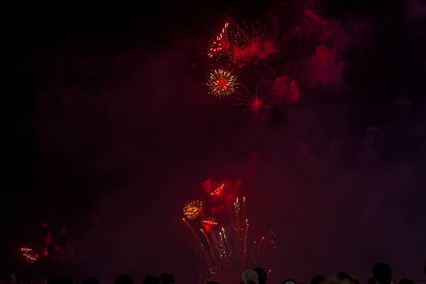 istock Big fireworks with silhouetted people in the foreground watching 589451166