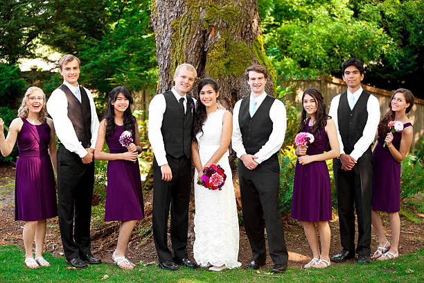 istock Wedding party standing outdoors with bride and groom 589452592