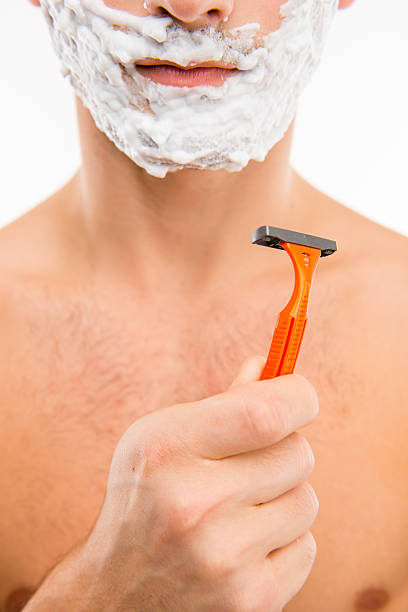 istock man with shaving foam on his face holding razor 589452702